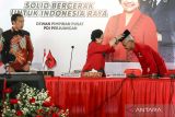 Ketua Umum PDI Perjuangan Megawati Soekarnoputri (tengah) menyematkan peci kepada calon Presiden 2024 yang diajukan PDI Perjuangan Ganjar Pranowo (kanan) disaksikan Presiden Joko Widodo (kiri) di Istana Batu Tulis, Bogor, Jawa Barat, Jumat (21/4/2023). PDI Perjuangan resmi menetapkan Gubernur Jawa Tengah Ganjar Pranowo sebagai calon presiden 2024. ANTARA FOTO/Monang/foc.