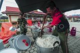 Prajurit TNI Bekang II/2. B Jambi memasak nasi di tempat pengungsian swadaya Simpang Tiga Rawang, Sungai Penuh, Jambi, Kamis (4/1/2024). Prajurit TNI mendirikan dapur umum di tempat pengungsian guna memberikan dukungan kepada lebih dari 600 orang warga korban banjir yang masih mengungsi di tempat itu. ANTARA FOTO/Wahdi Septiawan/nym.