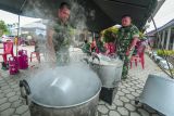 Prajurit TNI Bekang II/2. B Jambi memasak nasi di tempat pengungsian swadaya Simpang Tiga Rawang, Sungai Penuh, Jambi, Kamis (4/1/2024). Prajurit TNI mendirikan dapur umum di tempat pengungsian guna memberikan dukungan kepada lebih dari 600 orang warga korban banjir yang masih mengungsi di tempat itu. ANTARA FOTO/Wahdi Septiawan/nym