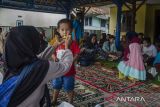 Warga memberi makan anaknya di posko pengungsian Desa Pasanggrahan, Kecamatan Kasomalang, Subang, Jawa Barat, Senin (8/1/2024). Berdasarkan data BPBD Jawa Barat, sebanyak 49 jiwa warga terdampak longsor di Subang terp[aksa mengungsi semenatar akibat retakan tanah di area pemukiman yang disebabkan longsor yang terjadi pada Minggu (7/1/2024). ANTARA FOTO/Novrian Arbi/agr