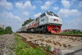 Kereta api Pasundan melintas di samping pembangunan rel ganda di Guruminda, Bandung, Jawa Barat, Rabu (10/1/2024). Kementerian Perhubungan mempercepat pembangunan jalur ganda kereta api Bandung-Cicalengka yang hingga Desember 2023 pembangunan tersebut telah mencapai 75 persen serta ditargetkan rampung pada pertengahan 2024. ANTARA FOTO/Raisan Al Farisi/agr