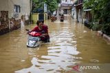 Warga mendorong sepeda motor melewati genangan banjir di Dayeuhkolot, Kabupaten Bandung, Jawa Barat, Jumat (12/1/2024). Berdasarkan data sementara BPBD Kabupaten Bandung, Sedikitnya ribuan bangunan terendam dan 40 ribu jiwa warga di total enam kecamatan di Kabupaten Bandung terdampak banjir akibat meluapnya aliran Sungai Citarum yang terjadi pada Kamis (11/1) malam. ANTARA FOTO/Novrian Arbi/agr
