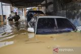 Warga berjalan melewati genangan banjir di Dayeuhkolot, Kabupaten Bandung, Jawa Barat, Jumat (12/1/2024). Berdasarkan data sementara BPBD Kabupaten Bandung, Sedikitnya ribuan bangunan terendam dan 40 ribu jiwa warga di total enam kecamatan di Kabupaten Bandung terdampak banjir akibat meluapnya aliran Sungai Citarum yang terjadi pada Kamis (11/1) malam. ANTARA FOTO/Novrian Arbi/agr
