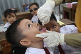 Petugas kesehatan memberikan imunisasi polio di SD Negeri Tempurejo 1, Kota Kediri, Jawa Timur, Senin (15/1/2024). Layanan jemput bola di sekolah tersebut sebagai upaya mensukseskan program pemerintah pemberian imunisasi polio serentak guna menanggulangi Kejadian Luar Biasa (KLB) polio. Antara Jatim/Prasetia Fauzani.