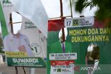 Warga melintas di dekat Alat Peraga Kampanye (APK) calon legislatif (caleg) pemilu 2024 yang dirusak orang tak dikenal di kawasan jembatan Pango, Banda Aceh, Aceh, Selasa (16/1/2024). Badan Pengawas Pemilu (Bawaslu) mengatakan berdasarkan UU nomor 7/2017 tentang pemilihan umum disebutkan perusakan dan penghilangan APK merupakan tindak pidana pemilu dengan ancaman pidana dua tahun penjara serta denda Rp24 juta. ANTARA/Irwansyah Putra