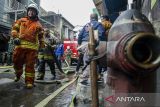 Petugas pemadam kebakaran melakukan pendinginan pascakebakaran panel listrik di Pasar Baru Trade Center, Bandung, Jawa Barat, Kamis (18/1/2024). Dinas Kebakaran dan Penanggulangan Bencana Kota Bandung berhasil mengatasi kebakaran panel cadangan listrik di area basemen yang sempat menimbulkan kepulan asap sehingga membuat kepanikan para pedagang dan pengunjung di Pasar Baru Bandung. ANTARA FOTO/Novrian Arbi/agr