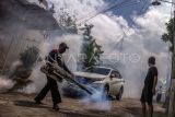 Petugas melakukan fogging atau pengasapan di kawasan permukiman, Depok, Jawa Barat, Sabtu (20/1/2024). Pengasapan yang dilakukan Dinkes Kota Depok tersebut guna mencegah penyebaran penyakit Demam Berdarah Dengue (DBD) yang disebabkan oleh gigitan nyamuk Aedes aegypti menyusul adanya temuan kasus penyakit DBD di daerah itu. ANTARA FOTO/Yulius Satria Wijaya/aww.