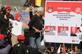 Calon presiden nomor urut 3 Ganjar Pranowo (kanan) bersama istri Siti Atikoh (kiri) melakukan simulasi mencoblos saat kampanye terbuka perdana bertajuk Hajatan Rakyat di Stadion Gelora Delta Sidoarjo, Jawa Timur, Minggu (21/1/2024). Hajatan Rakyat yang merupakan singkatan dari harapan ribuan rakyat itu mengusung konsep merakyat seperti sosok Ganjar yang sederhana dan dekat dengan rakyat. Antara Jatim/Umarul Faruq.