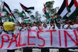 Warga meneriakkan yel-yel dalam Aksi Damai Bela Palestina di kawasan Bundaran Digulis, Pontianak, Kalimantan Barat, Sabtu (13/1/2024). Aksi untuk memperingati 100 hari agresi dan genosida di Jalur Gaza tersebut dilakukan sebagai bentuk solidaritas dan kepedulian terhadap rakyat Palestina yang mengalami serangan militer Israel. ANTARA FOTO/Jessica Wuysang/nym. 