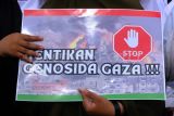 Warga memajang poster dan tulisan dalam Aksi Damai Bela Palestina di kawasan Bundaran Digulis, Pontianak, Kalimantan Barat, Sabtu (13/1/2024). Aksi untuk memperingati 100 hari agresi dan genosida di Jalur Gaza tersebut dilakukan sebagai bentuk solidaritas dan kepedulian terhadap rakyat Palestina yang mengalami serangan militer Israel. ANTARA FOTO/Jessica Wuysang/nym. 