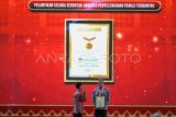 Ketua KPU RI Hasyim Asy'ari (kanan) menerima penghargaan dari Direktur Operasional MURI Yusuf Ngadri (kiri) saat acara Pelantikan Serentak KPPS dan Penganugerahan Rekor MURI di Merlynn Hotel, Jakarta, Kamis (25/1/2024). KPU serentak melantik sebanyak 5.741.127 Kelompok Penyelenggara Pemungutan Suara (KPPS) yang tersebar di 820.161 Tempat Pemungutan Suara (TPS) se-Indonesia secara daring, serta melakukan penanaman 5.709.898 bibit pohon pada seluruh KPPS yang kemudian mendapatkan tiga penghargaan MURI dari kegiatan tersebut. ANTARA FOTO/Sulthony Hasanuddin. 