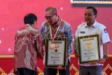 Ketua KPU Hasyim Asy'ari (tengah) dan Sekjen KPU Bernad Dermawan Sutrisno (kanan) menerima penghargaan dari Direktur Operasional MURI Yusuf Ngadri (kiri) saat acara Pelantikan Serentak KPPS dan Penganugerahan Rekor MURI di Merlynn Hotel, Jakarta, Kamis (25/1/2024). KPU serentak melantik sebanyak 5.741.127 Kelompok Penyelenggara Pemungutan Suara (KPPS) yang tersebar di 820.161 Tempat Pemungutan Suara (TPS) se-Indonesia secara daring, serta melakukan penanaman 5.709.898 bibit pohon pada seluruh KPPS yang kemudian mendapatkan tiga penghargaan MURI dari kegiatan tersebut. ANTARA FOTO/Sulthony Hasanuddin/foc. 