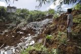 Warga mengamati lokasi tanah longsor di Cibatuhilir, Sekarwangi, Cibadak, Kabupaten Sukabumi, Jawa Barat, Jumat (26/1/2024). Badan Penanggulangan Bencana Daerah (BPBD) Kabupaten Sukabumi mencatat akibat tanah longsor yang terjadi Rabu (24/1/2024) sebanyak 12 rumah warga rusak berat dan sebanyak 75 Kepala Keluarga (KK) atau 239 warga terpaksa mengungsi di tenda pengungsian. ANTARA FOTO/Henry Purba/agr/foc.