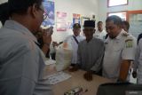 Pj Bupati Aceh Besar, Muhammad Iswanto (kanan) berbincang dengan warga penerima  bantuan  pangan cadangan beras pemerintah tahun 2024  di kantor Pos Peukan Bada, kabupaten Aceh Besar, Aceh, Rabu (31/1/2024). PT Pos Indonesia  memastikan kecepatan dan ketepatan distribusi penyaluran bantuan pangan cadangan beras pemerintah tahun 2024  di 20 propvinsi kepada  22 juta  keluarga penerima manfaat (KPM). ANTARA FOTO/Ampelsa.