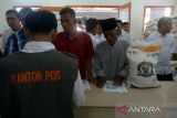Warga menerima bantuan pangan cadangan beras pemerintah saat penyaluran perdana tahun 2024 di kantor Pos Peukan Bada, kabupaten Aceh Besar, Aceh, Rabu (31/1/2024). PT Pos Indonesia  memastikan kecepatan dan ketepatan distribusi penyaluran bantuan pangan cadangan beras pemerintah tahun 2024  di 20 propvinsi , termasuk Aceh kepada  22 juta  keluarga penerima manfaat (KPM). ANTARA FOTO/Ampelsa.