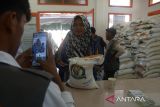 Petugas PT Pos  merekam data warga saat penyaluran perdana bantuan pangan cadangan beras pemerintah tahun 2024 di kantor Pos Peukan Bada, kabupaten Aceh Besar, Aceh, Rabu (31/1/2024). PT Pos Indonesia  memastikan kecepatan dan ketepatan distribusi penyaluran bantuan pangan cadangan beras pemerintah tahun 2024  di 20 propvinsi kepada  22 juta  keluarga penerima manfaat (KPM). ANTARA FOTO/Ampelsa.