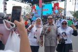Pendukung berpose dua jari dengan Usman Yahya (70) warga Lhokseumawe yang disebut mirip Prabowo Subianto saat menghadiri deklarasi dukungan Milenial Aceh untuk Prabowo - Gibran di pelantaran parkir Stadion H Dimurthala, Banda Aceh, Aceh, Sabtu (3/2/2024).