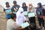 Gubernur Jawa Timur Khofifah Indar Parawansa (ketiga kiri) menyalurkan zakat produktif kepada warga di Kota Kediri, Jawa Timur, Jumat (2/2/2024). Gubernur Jatim Khofifah Indar Parawansa menyalurkan zakat produktif berupa modal usaha dari Badan Usaha Milik Daerah (BUMD) kepada sejumlah pelaku usaha ultra mikro di Kota Kediri. Antara Jatim/Prasetia Fauzani.