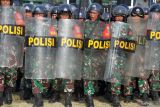 Personel gabungan TNI Korem 011 Lilawangsa dan Polisi Polres Lhokseumawe  menghadang pengunjuk rasa yang anarkis saat Latihan Pengamanan Pemilu 2024 di Lhokseumawe, Aceh, Senin (5/2/2024). Latihan sinergitas TNI-Polri itu digelar guna meningkatkan kemampuan personel untuk kesiapsiagaan TNI-Polri di daerah dalam melakukan pengamanan Pemilu 2024. Antara Aceh/Rahmad.