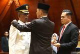 Penjabat (Pj) Gubernur Aceh Achmad Marzuki (tengah) menyematkan tanda pangkat dan jabatan pada Jailani Beuramat (kiri) pada prosesi pelantikan Pj Bupati Pidie Jaya di Banda Aceh, Aceh, Senin (5/2/2024). Jalaini Beuramat dilantik sebagai Pj Bupati Kabupaten Pidie Jaya menggantikan Said Mulyadi yang telah purna tugas. Antara Aceh/Irwansyah Putra.(ANTARA FOTO/IRWANSYAH PUTRA)