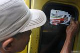 Seorang sopir membersihkan stiker alat peraga kampanye (APK) di angkutannya di Terminal Tawang Alun, Jember, Jawa Timur, Senin (12/2/2024). Petugas gabungan dari Bawaslu, Dinas Perhubungan dan Satpol PP membersihkan APK yang terpasang di angkutan umum dalam masa tenang Pemilu 2024. Antara Jatim/Seno.