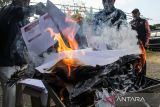 Petugas Komisi Independen Pemilihan (KIP) membakar surat suara rusak saat pemusnahan di Gudang Logistik KIP Lhokseumawe, Aceh, Selasa (13/2/2024). Pemusnahan 599 lembar surat suara yang rusak dan tidak layak digunakan tersebut untuk menghindari penyalahgunaan serta potrensi kecurangan dalam Pemilu 2024. ANTARA/Rahmad