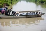 Petugas gabungan membawa kotak suara menggunakan perahu tradisional saat mendistribusikan logistik Pemilu ke TPS Dusun Kepentingan, Desa Sawohan, Kecamatan Buduran, Sidoarjo, Jawa Timur, Selasa (13/2/2024). Kelompok Penyelenggara Pemungutan Suara (KPPS) harus menyeberangi sungai untuk mendistribusikan logistik Pemilu 2024 ke TPS di kawasan terpencil. Antara Jatim/Umarul Faruq.