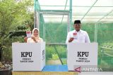 Penjabat Gubernur Kepulauan Bangka Belitung Safrizal ZA bersama istrinya Safriati Safrizal menunjukkan surat suara Pemilu 2024 sebelum melakukan pencoblosan di TPS 17 Kelurahan Padang Lama Kota Pangkalpinang, Rabu (14/2/2024) pagi. ANTARA-HO/Humas Diskominfo Babel
