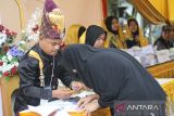 Petugas KPPS mengenakan pakaian adat Aceh atau pakaian Pahlawan Nasional Teuku Umar dan Cut Nyak Dhien di TPS 04 Desa Kampung Belakang, Johan Pahlawan, Aceh Barat, Aceh, Rabu (14/2/2024). Pemakaian baju adat Aceh tersebut sebagai daya tarik untuk warga agar datang ke TPS untuk memberikan hak pilihnya. Antara Aceh/Syifa Yulinnas