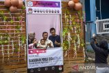 Pemilih berfoto dengan keluarganya usai menggunakan hak suara pada Pemilu 2024 di TPS 15 dengan dekorasi pernikahan di Bandung, Jawa Barat, Rabu (14/2/2024). Sekitar 80 persen pemilih dari total 261 daftar pemilih tetap di TPS tersebut menggunakan hak suaranya. ANTARA FOTO/Novrian Arbi/agr
