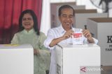 Presiden Joko Widodo (kanan) bersama Ibu Negara Iriana (kiri) memasukkan surat suara ke dalam kotak pada Pemilu 2024 di tempat pemungutan suara (TPS) 10 Kelurahan Gambir, kompleks Kantor Lembaga Administrasi Negara (LAN), Jakarta, Rabu (14/2/2024). Presiden Jokowi dan Ibu Negara Iriana menggunakan hak suaranya pada Pemilu 2024 untuk memilih Presiden dan Wakil Presiden, anggota DPR, DPD, DPRD Provinsi dan DPRD Kabupaten/Kota. ANTARA FOTO/Muhammad Adimaja/wsj.