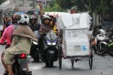 Polisi mengawal tukang becak yang mengangkut logistik Pemilu 2024 di Jalan Kebalen Timur, Surabaya, Jawa Timur, Selasa (13/2/2024). Logistik Pemilu 2024 di Kantor Kelurahan Krembangan Utara didistribusikan dari panitia Pemungutan Suara (PPS) tingkat kelurahan menuju ke Tempat Pemungutan Suara (TPS) dengan pengawalan pihak kepolisian dan Bawaslu. Antara Jatim/Didik Suhartono.