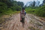 Seorang warga masyarakat adat Suku Talang Mamak melintas di jalan kawasan restorasi Alam Bukit Tigapuluh, Semerantihan, Tebo, Jambi, Selasa (13/2/2024). Warga masyarakat adat Suku Talang Mamak yang mendiami kawasan penyangga Taman Nasional Bukit Tigapuluh berharap Pemilu 2024 menghasilkan presiden dan wakil rakyat yang bisa memperjuangkan harapan mereka untuk mendapatkan akses jalan yang layak. ANTARA FOTO/Wahdi Septiawan/Spt.