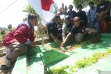 Sejumlah pegiat sejarah menancapkan bendera mera putih di makam pahlawan nasional Tan Malaka di Desa Selopanggung, Kediri, Jawa Timur, Rabu (21/2/2024). Doa bersama, mimbar bebas, dan diakhiri dengan kenduri oleh sejumlah pegiat sejarah lintas komunitas tersebut guna memperingati 75 tahun gugurnya pahlawan nasional Tan Malaka. Antara Jatim/Prasetia Fauzani.