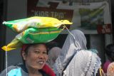 Warga menyunggih beras murah SPHP yang dibelinya di Kios TPID di Pasar Genteng Baru, Surabaya, Jawa Timur, Kamis (22/2/2024). Kios itu menjual beras murah dengan harga jual Rp10.900 per kilogram bagi masyarakat yang membelinya dan Rp10.400 per kilogram bagi pedagang yang membelinya serta menjualnya kembali. Antara Jatim/Didik Suhartono.