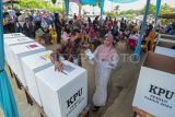 Warga didampingi petugas bersiap memasukkan kertas suara usai pencoblosan Pemungutan Suara Ulang (PSU) Pemilu 2024 di TPS 66, Simpang Rimbo, Jambi, Sabtu (24/2/2024). Komisi Pemilihan Umum (KPU) setempat menetapkan PSU serentak di 12 TPS yang tersebar di Kota Jambi, Kabupaten Batanghari, dan Tebo. ANTARA FOTO/Wahdi Septiawan/nz.
