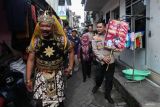 Polisi menggunakan kostum wayang Gatotkaca mengajak warga untuk menggunakan hak pilihnya saat digelarnya Pemungutan Suara Ulang (PSU) di Tempat Pemungutan Suara (TPS) 27 Kelurahan Simolawang, Kecamatan Simokerto, Surabaya, Jawa Timur, Sabtu (24/2/2024). Komisi Pemilihan Umum (KPU) Kota Surabaya menggelar Pemungutan Suara Ulang (PSU) di sepuluh TPS di Surabaya atas rekomendasi Badan Pengawas Pemilihan Umum (Bawaslu) Kota Surabaya berdasarkan temuan adanya surat suara calon legislatif DPRD Kota Surabaya yang tidak sesuai dapil serta persoalan pemilih yang tetap menggunakan hak pilihnya namun tidak masuk dalam DPT, DPTb, maupun DPK. Antara Jatim/Didik Suhartono.