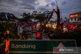 Petugas BPBD, Basarnas dan Dinas Pemadam Kebakaran mengevakuasi pohon yang tumbang pascaputing beliung yang terjadi di Jalan Nasional Bandung Garut di Rancaekek, Kabupaten Bandung, Jawa Barat, Rabu (21/2/2024). BPBD Provinsi Jawa Barat tengah mendata kerusakan bangunan dan korban akibat bencana puting beliung yang terjadi di Rancaekek pada Rabu petang tersebut. ANTARA FOTO/Raisan Al Farisi/agr