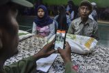 Petugas merekam data warga saat penyaluran Bantuang Sosial (Bansos) Cadangan Beras Pemerintah (CBP) di Desa Manonjaya, Kabupaten Tasikmalaya, Jawa Barat, Senin (19/2/2024). Pemerintah melanjutkan program pembagian bansos untuk bantuan pangan beras seberat 10 kilogram dengan total sasaran penerima sebanyak 22.004.077 Keluarga Penerima Manfaat (KPM). ANTARA FOTO/Adeng Bustomi/agr
