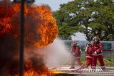 Peserta berusaha memadamkan api yang membakar saluran pipa saat lomba Fire Combat di Pertamina EP Jatibarang Field, Indramayu, Jawa Barat, Senin (26/2/2024). Lomba yang diadakan Pertamina EP dalam rangka memperingati bulan K3 Nasional tahun 2024 tersebut bertujuan untuk mengasah kesiapsiagaan sekaligus kemampuan para pekerja dalam menangani kondisi darurat kebakaran di area hulu migas. ANTARA FOTO/Dedhez Anggara/agr