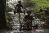 Anak-anak mengemudi permainan tradisional balap Kadaplak di Kampung Pasir Angling, Kabupaten Bandung Barat, Jawa Barat, Senin (26/2/2024). Kadaplak yang pada zaman Belanda sempat dimanfaatkan untuk mengangkut hasil tani dan tembakau tersebut kembali dihadirkan masyarakat kampung Pasir Angling guna mengenalkan dan mengedukasi agar permainan tradisional itu tetap lestari di tengah perkembangan teknologi. ANTARA FOTO/Novrian Arbi/agr
