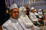 Pasangan warga disabilitas mengikuti pernikahan massal di Taman Budaya, Bandung, Jawa Barat, Rabu (28/2/2024). Mimbar Hiburan Amal dan Dhuafa (MHABD) menggelar pernikahan massal bagi warga disabilitas untuk ke-35 kali nya, serta memberikan santunan dalam rangka menyambut Bulan Suci Ramadhan. ANTARA FOTO/Raisan Al Farisi/agr
