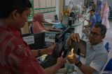 Perekaman biometrik visa jemaah haji 2024. Petugas Kantor Wilayah Kementerian Agama (Kemenag) Kota Banda Aceh membantu jemaah calon haji melakukan pemindaian sidik jari saat perekaman biometrik melalui aplikasi Saudi Visa Bio di Banda Aceh, Aceh, Rabu (28/2/2024). Kementerian Agama melakukan proses perekaman biometrik bagi jemaah calon haji 2024 M/1445 H yang meliputi perekaman wajah, sidik jari, serta pencatatan data diri menggunakan aplikasi Saudi Visa Bio untuk penerbitan visa haji. ANTARA FOTO/Khalis Surry