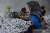 Pekerja menyelesaikan pembuatan batik tulis di rumah produksi Agnesha di Ciroyom, Kota Tasikmalaya, Jawa Barat, Rabu (28/2/2023). Kementerian Perindustrian (Kemenperin) mendorong pemerintah daerah untuk memanfaatkan Dana Alokasi Khusus (DAK) bidang Industri Kecil dan Menengah (IKM) untuk melakukan pembangunan atau revitalisasi sentra IKM di sektor batik demi menciptakan para perajin batik yang lebih berdaya saing. ANTARA FOTO/Adeng Bustomi/agr