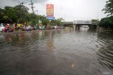 Warga melewati banjir di kawasan Jalan Raya Jati, Sidoarjo, Jawa Timur, Senin (26/2/2024). Hujan deras yang mengguyur kawasan tersebut menyebabkan banjir sepanjang 200 meter dengan ketinggian mencapai 50 cm Antara Jatim/Umarul Faruq.
