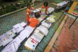 Siswa menjemur buku yang basah akibat kehujanan di sekolah kawasan Sumput, Sidoarjo, Jawa Timur, Selasa (27/2/2024). Empat ruang kelas di sekolah itu rusak akibat hujan deras dan angin kencang pada Senin (26/2) sore. Antara Jatim/Umarul Faruq.
