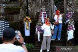 Wisatawan domestik berfoto saat mengunjungi kawasan Desa Wisata Penglipuran yang bertepatan dengan Hari Raya Galungan di Bangli, Bali, Rabu (28/2/2024). Kementerian Pariwisata dan Ekonomi Kreatif berupaya meningkatkan kunjungan wisatawan nusantara yang pada tahun 2024 ditargetkan mencapai 1,25-1,5 miliar pergerakan salah satunya dengan berkolaborasi dengan berbagai asosiasi travel dan agen perjalanan wisata daring untuk menghadirkan paket promo wisata domestik. ANTARA FOTO/Fikri Yusuf/wsj.