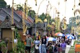 Wisatawan domestik berjalan di sekitar deretan rumah tradisional yang dihiasi penjor saat perayaan Hari Raya Galungan di Desa Wisata Penglipuran, Bangli, Bali, Rabu (28/2/2024). Kementerian Pariwisata dan Ekonomi Kreatif berupaya meningkatkan kunjungan wisatawan nusantara yang pada tahun 2024 ditargetkan mencapai 1,25-1,5 miliar pergerakan salah satunya dengan berkolaborasi dengan berbagai asosiasi travel dan agen perjalanan wisata daring untuk menghadirkan paket promo wisata domestik. ANTARA FOTO/Fikri Yusuf/wsj.