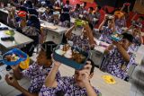 Sejumlah siswa menunjukkan makanan gratis saat simulasi program makan siang gratis di SMP Negeri 2 Curug, Kabupaten Tangerang, Banten, Kamis (29/2/2024). Menko Perekonomian Airlangga Hartarto meyediakan 162 porsi dengan empat macam menu makanan sehat senilai Rp15 ribu per porsi pada simulasi program makan siang gratis itu. ANTARA FOTO/Sulthony Hasanuddin