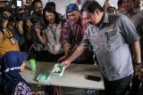 Menko Perekonomian Airlangga Hartarto melihat menu makanan milik siswa saat simulasi program makan siang gratis di SMP Negeri 2 Curug, Kabupaten Tangerang, Banten, Kamis (29/2/2024). Menko Perekonomian Airlangga Hartarto meyediakan 162 porsi dengan empat macam menu makanan sehat senilai Rp15 ribu per porsi pada simulasi program makan siang gratis. ANTARA FOTO/Sulthony Hasanuddin/Spt.